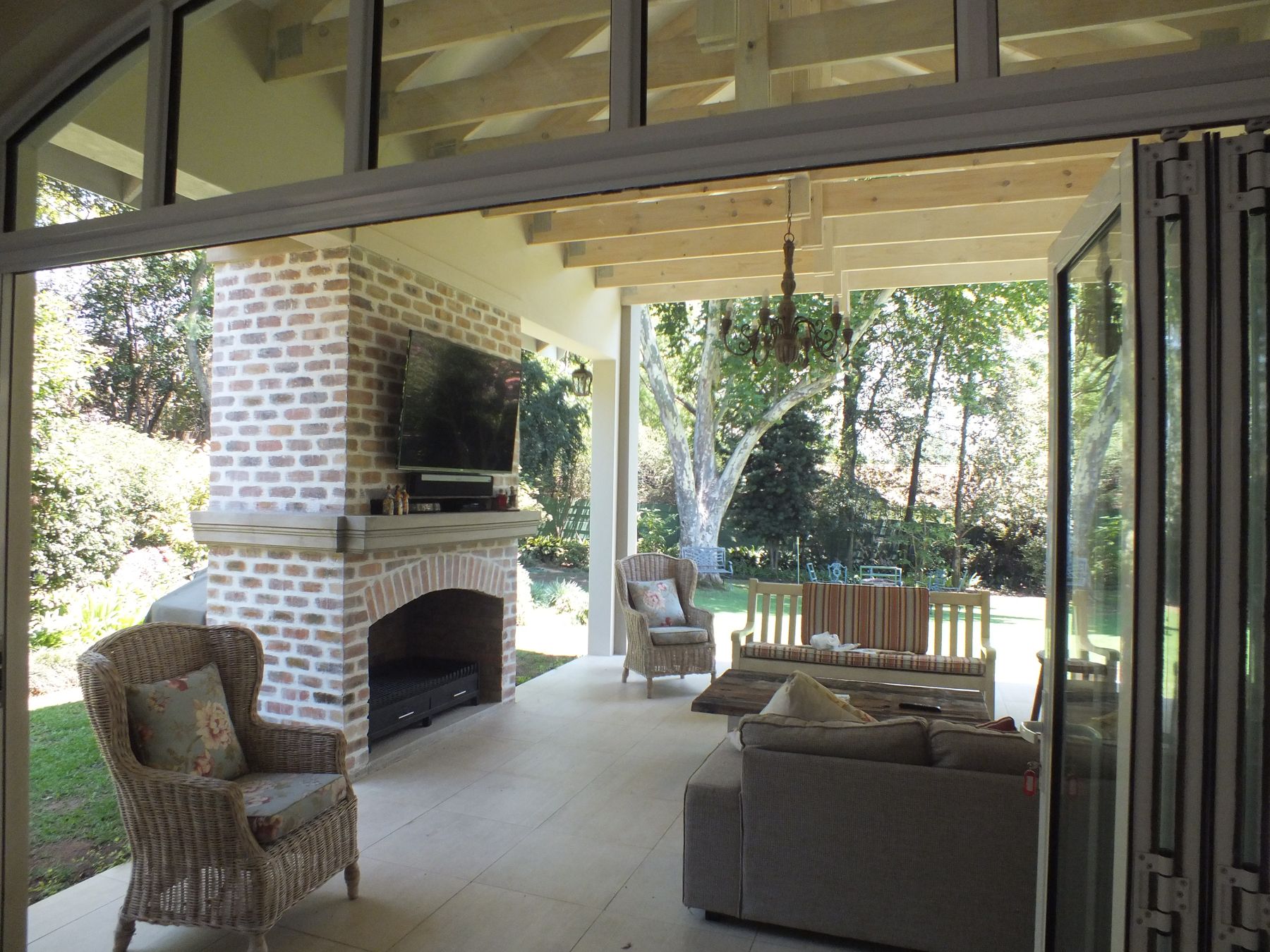 Pavilion interior — brick fireplace and folding doors — House in Atholl