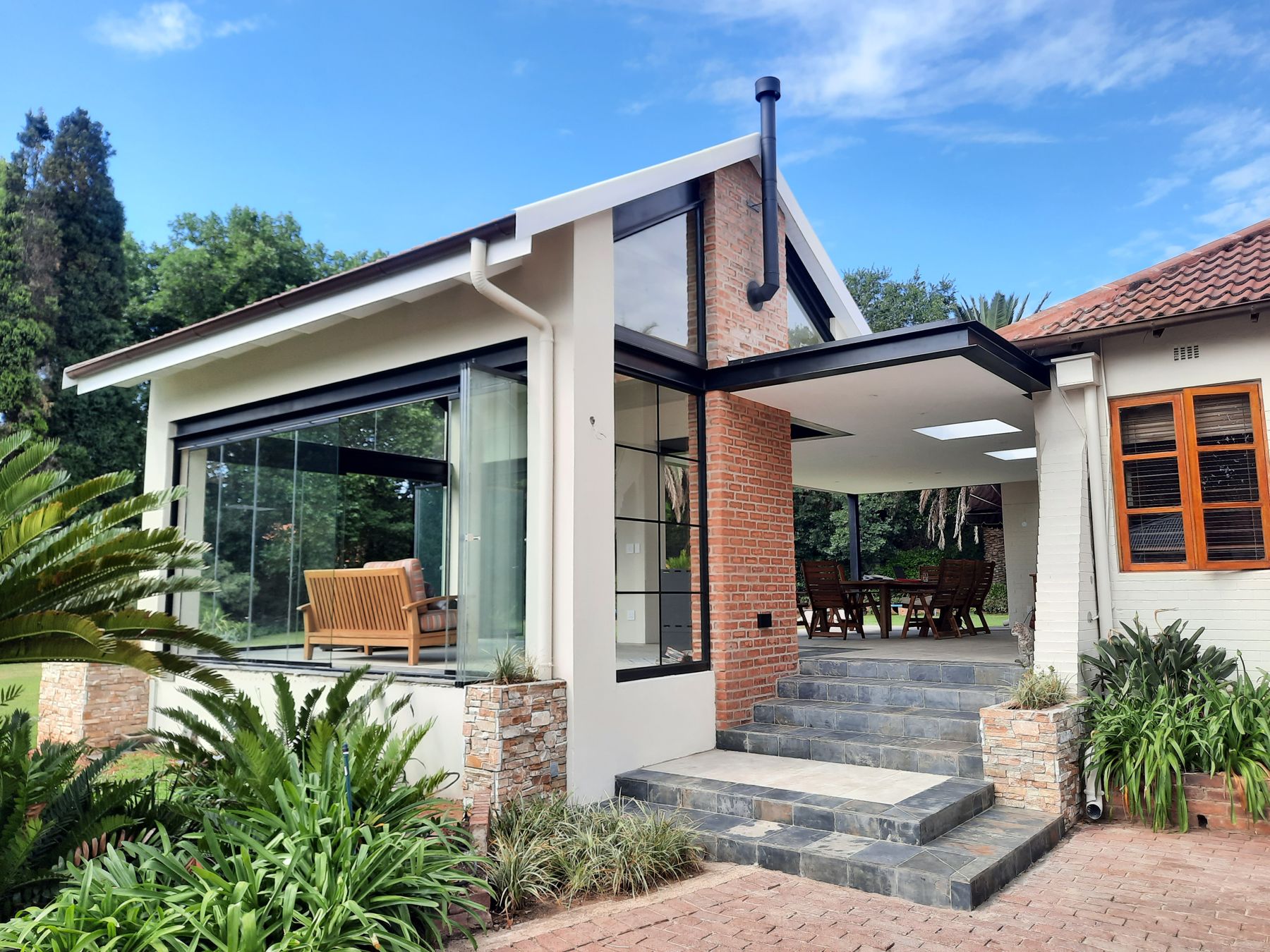 Glazed gable pavilion added to a tiled-roof heritage house in Saxonwold