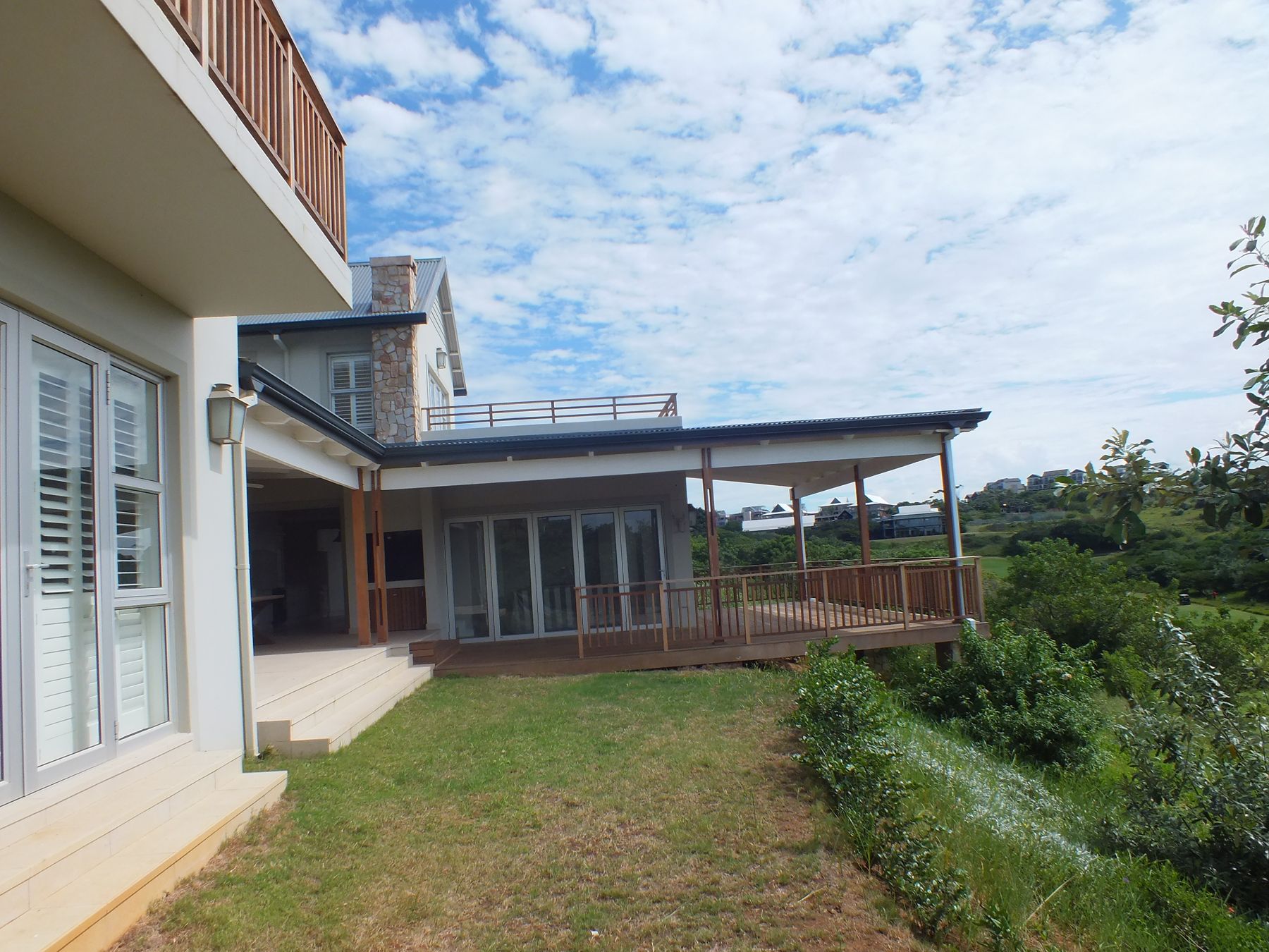 The completed Simbithi house from the garden, with its wrap-around timber verandah